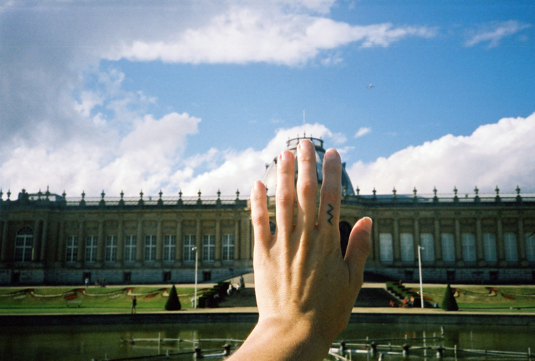 hand of photographer blocking shot of elaborate building