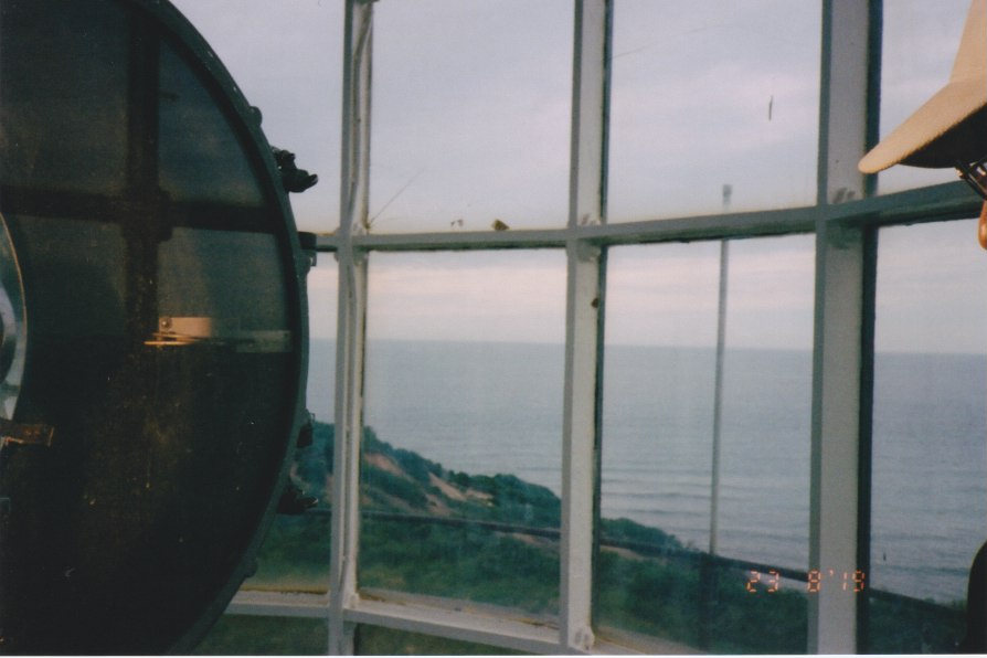light in lighthouse shining on the brim of a person's hat and nose