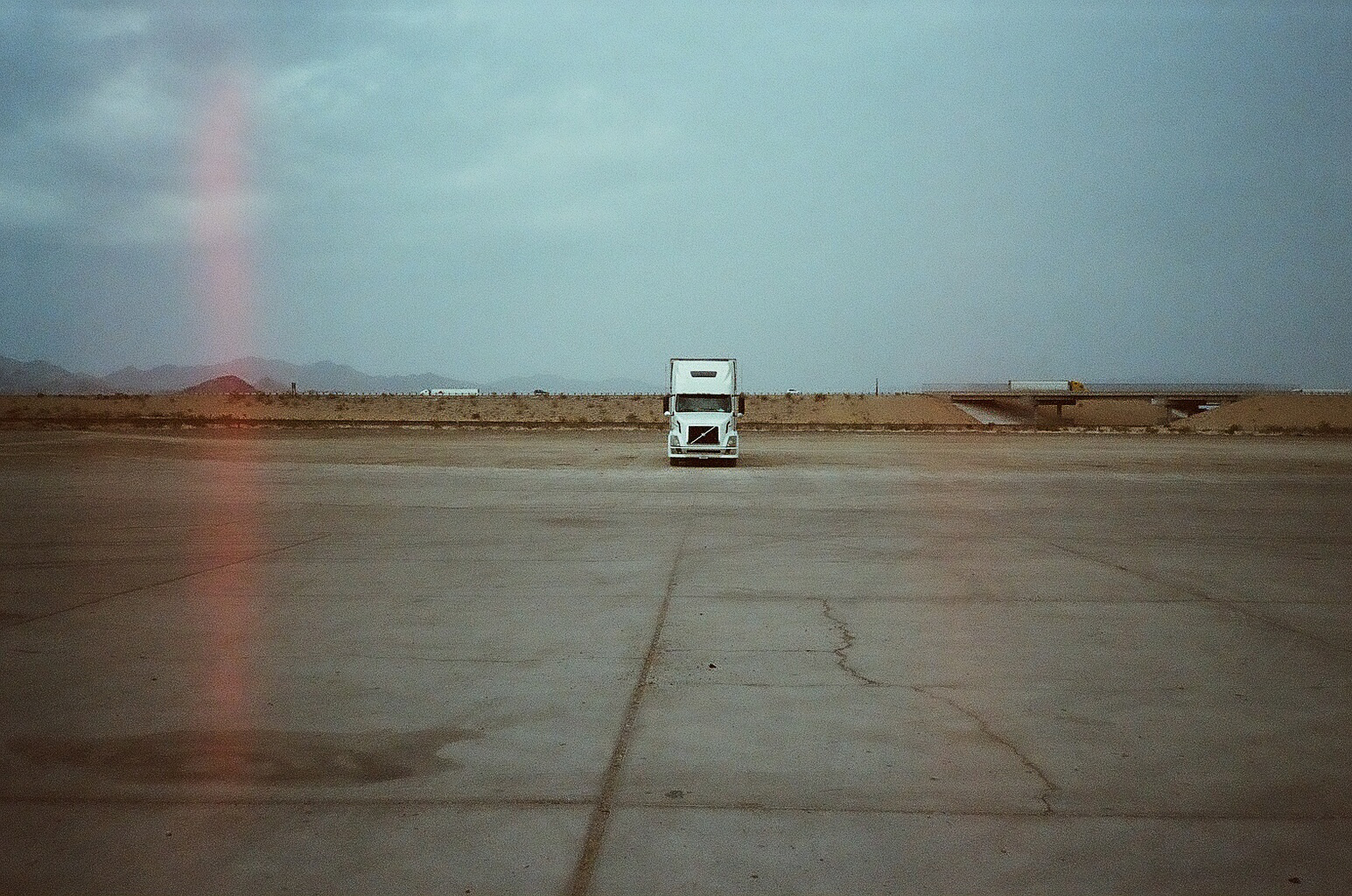 solitary semi-truck in empty desert parking lot